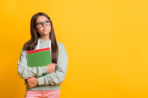 Ritratto di bella ragazza sguardo sospettoso spazio vuoto nuova idea torna in classe isolato su sfondo di colore giallo