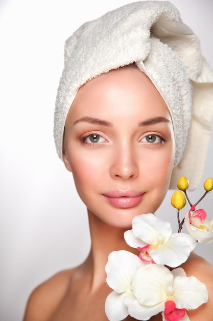 Photo portrait of beautiful girl touching face with a towel on her head