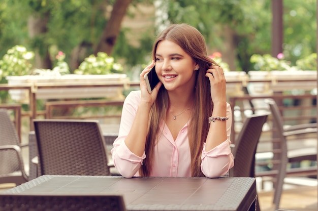 Portrait of beautiful girl using her mobile phone in cafe.