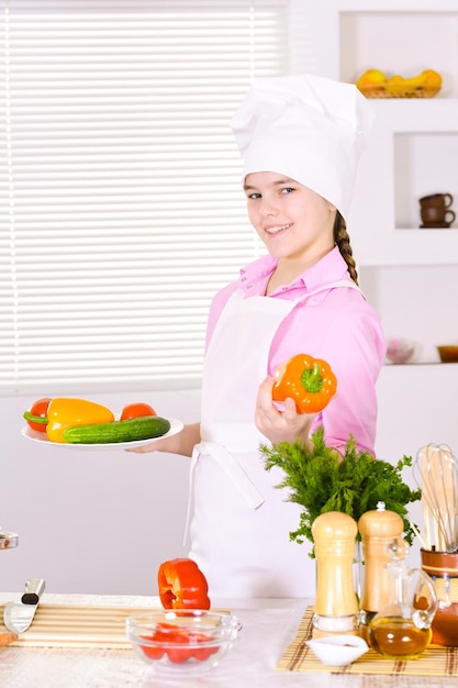 Portrait of beautiful girl wearing chef uniform with vegetables