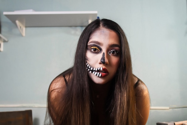 Portrait of a beautiful girl with artistic skull makeup. Halloween Makeup