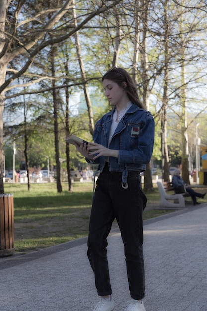 Photo portrait of a beautiful girl with a book it's happening somewhere in the park closeup