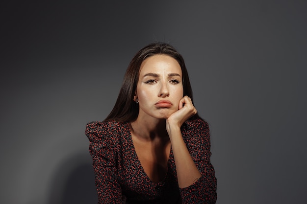 Foto ritratto di una bella ragazza con emozioni luminose su uno sfondo neutro