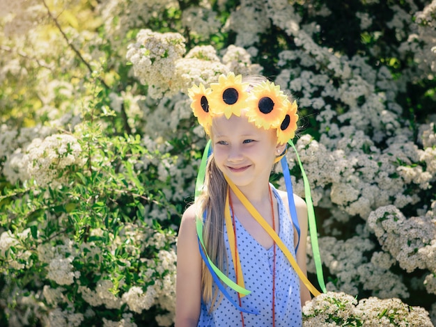 Ritratto di una bella ragazza con fiori di girasoli in testa.