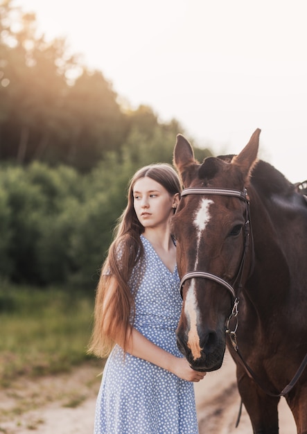 Photo portrait of a beautiful girl with long hair and a brown horse