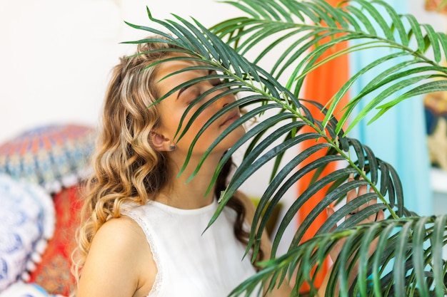 Photo portrait of beautiful girl with palm leaf