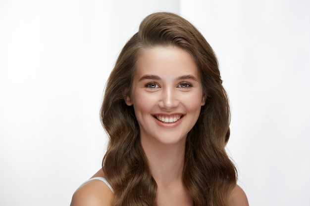 Portrait of beautiful girl with perfect curly hair and lovely smile