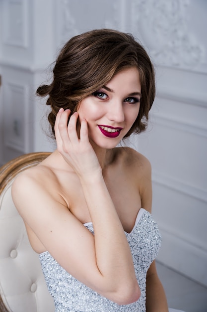 Portrait of a beautiful girl with red lips. Beauty face. Wedding image in the luxury interior