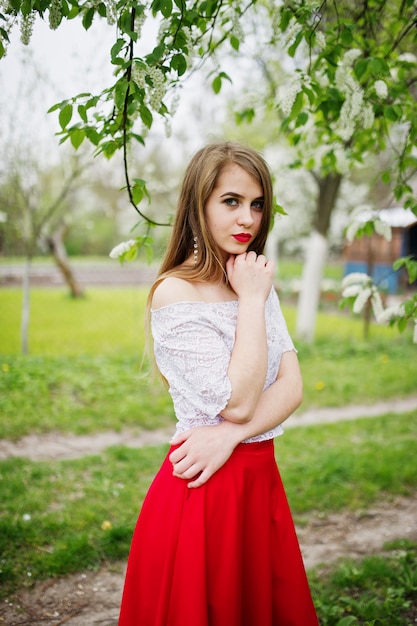 봄 꽃 정원에서 붉은 입술으로 아름 다운 여자의 초상화 빨간 드레스와 흰 블라우스에 착용.