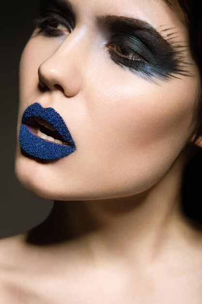 Portrait of beautiful girl with unusual blue lips and eyes closed Picture taken in the studio