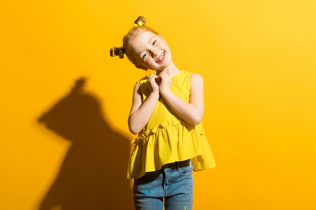 Portrait of a beautiful girl in a yellow blouse and blue jeans.