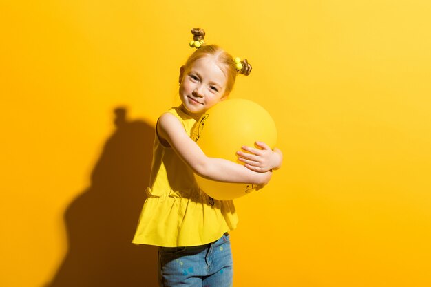 Portrait of a beautiful girl in a yellow blouse and blue jeans.