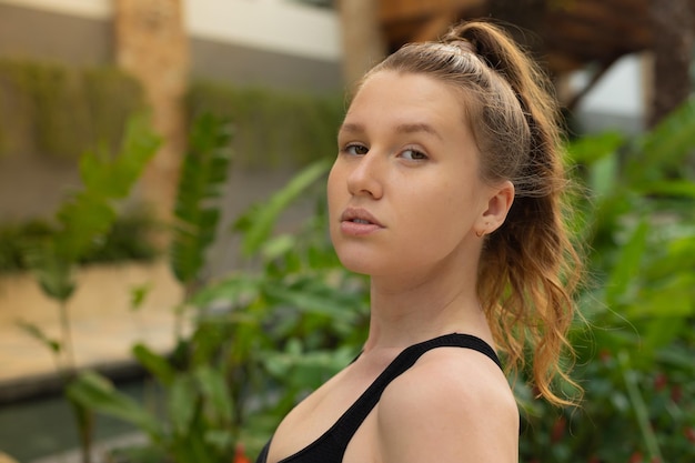 Portrait of beautiful girl young serious woman looking at camera at summer sunny day with ponytail