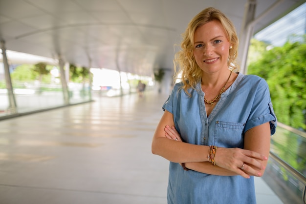 Portrait of beautiful happy blonde woman smiling outdoors