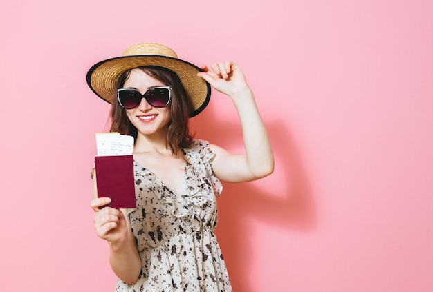 Портрет красивой счастливой брюнетки девушка держит проездные билеты и паспорт