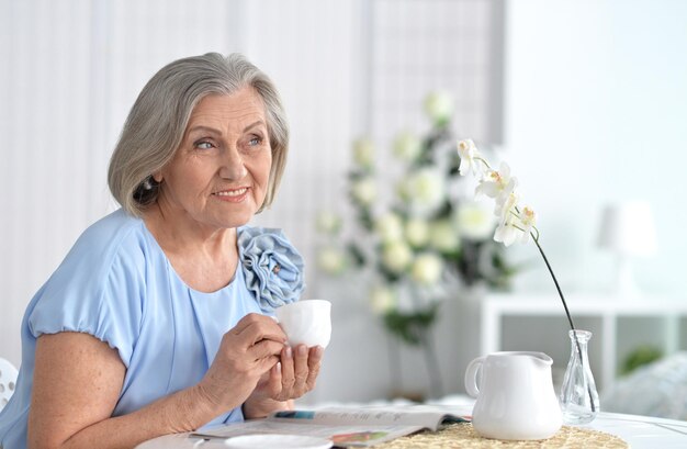 Photo portrait of a beautiful happy elderly woman with a cup of tea