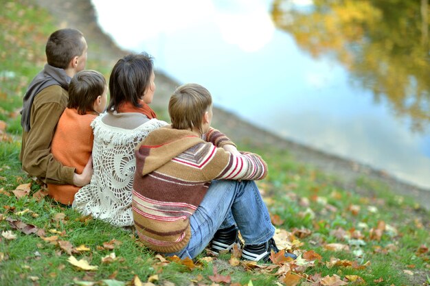 Portrait of a beautiful happy family in autumn park near lake