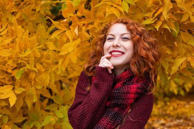 Ritratto di una bella ragazza dai capelli rossi felice foglie gialle