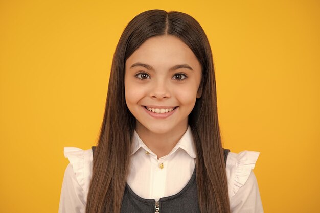 Foto ritratto di una bella adolescente felice e sorridente sullo sfondo giallo dello studio