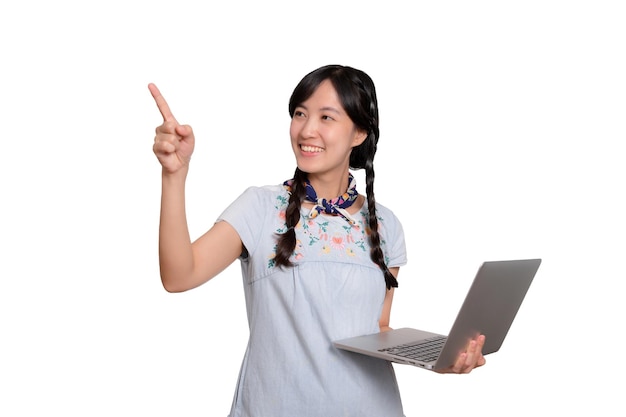 Portrait of beautiful happy young freelance asian woman in denim dress using laptop work with success on white background