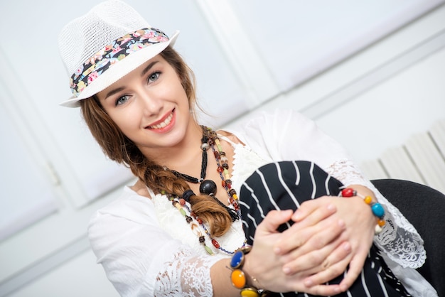 Portrait of a beautiful hippie girl with white summer hat