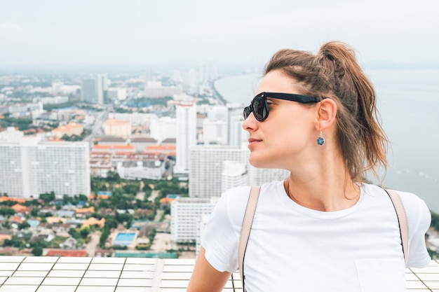 Portrait of beautiful hipster model dressed in summer clothes. Trendy girl posing in the street background