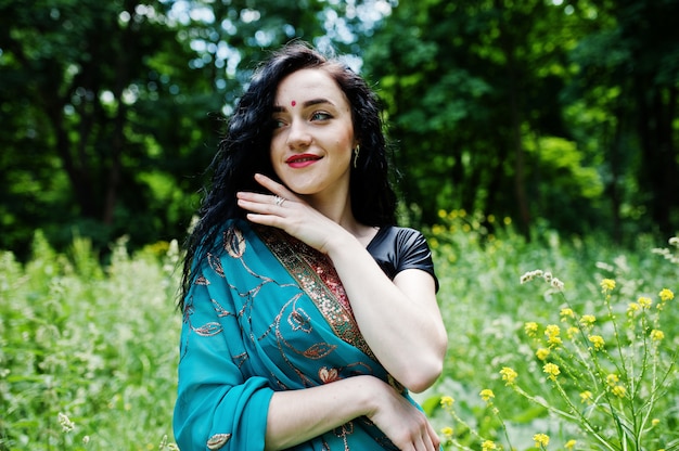 Portrait of beautiful indian brumette girl or hindu woman model. Traditional Indian costume lehenga choli.