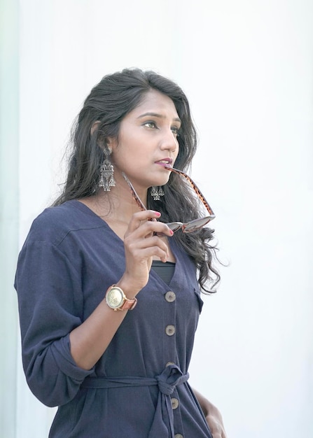 Portrait of a beautiful Indian woman fashion model holding sunglasses with her hand