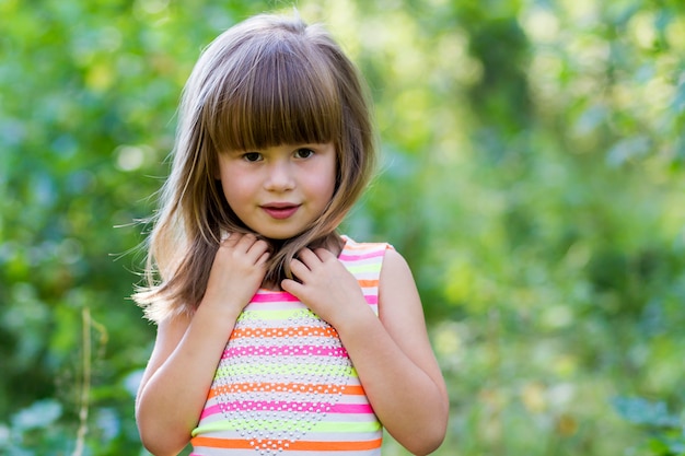 Portrait of beautiful little girl with dark hair outside