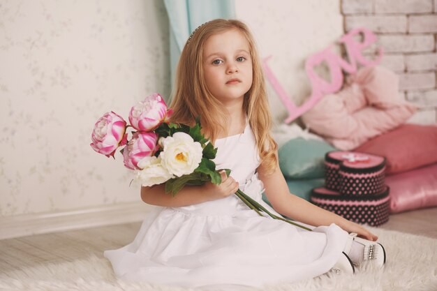 Photo portrait of a beautiful little girl with flowers