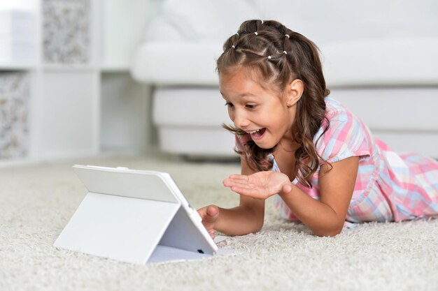 Photo portrait of beautiful little girl with tablet pc