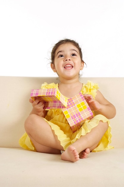 Portrait of a beautiful little girl in a yellow dress on a white background