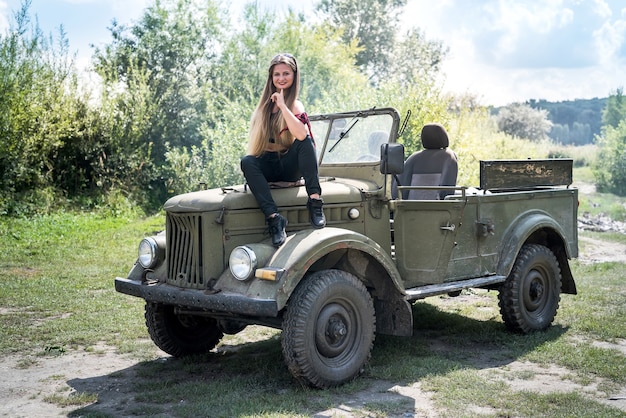 Portrait of beautiful long hair woman sitting on car hood