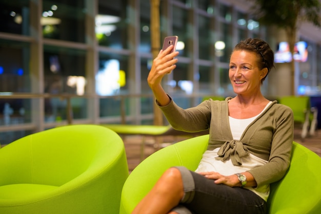 Portrait of beautiful mature tourist woman enjoying life while travelling in Singapore city