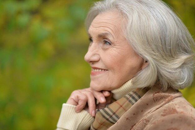 Portrait of a beautiful middle-aged woman in autumn park