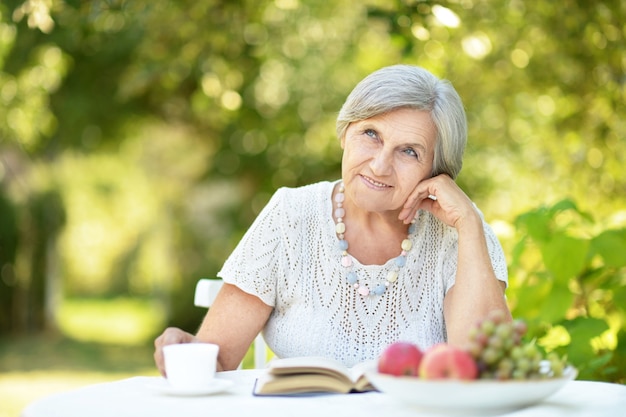 Portrait of a beautiful middle-aged woman outdoors at the table