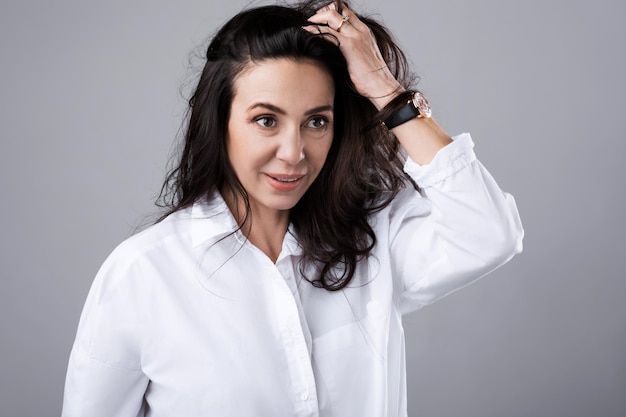 Portrait of beautiful middle aged woman wearing white shirt  in photo studio