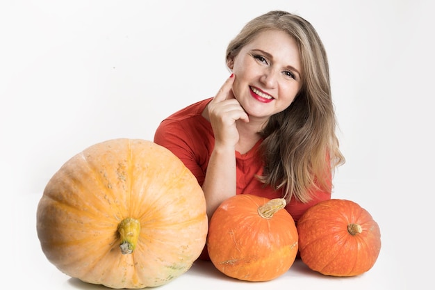 Ritratto di bella donna bionda di mezza età con zucca pronta per la celebrazione di halloween mockup per cartolina e invito o pubblicità