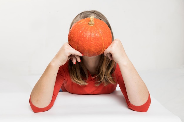 Ritratto di bella donna bionda di mezza età con zucca pronta per la celebrazione di halloween mockup per cartolina e invito o pubblicità