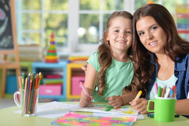 Portrait of beautiful mother and daughter painting