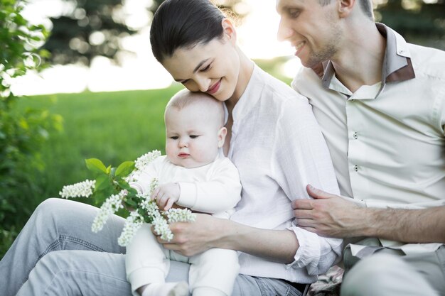 Portrait Beautiful Mother Father And Baby outdoors Happy family on a summer meadow