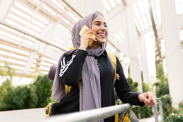 Portrait of a beautiful Muslim woman smiling and relaxing with a digital smartphone