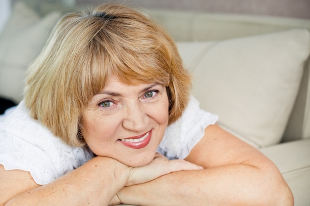 Portrait of a beautiful older blonde woman in the living room