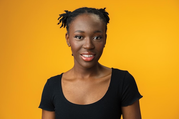 Photo portrait of beautiful positive african american woman in yellow studio