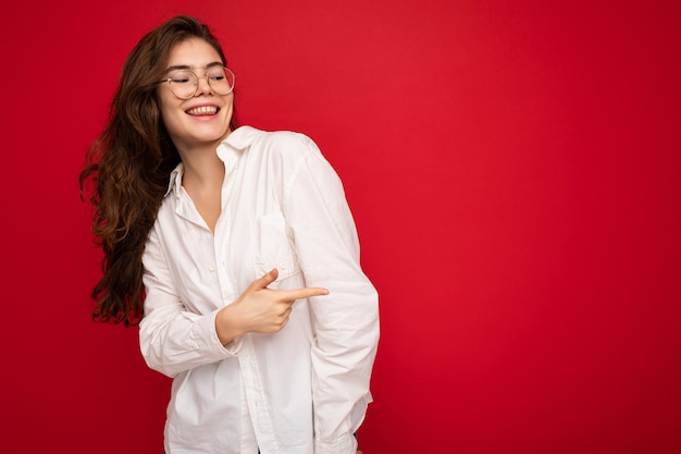 Portrait of beautiful positive cheerful cute smiling young brunette woman in casual white shirt and