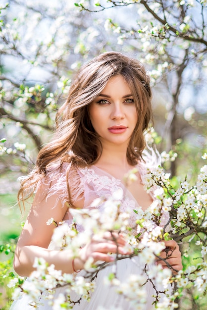 Portrait of a beautiful pregnant girl in the spring garden