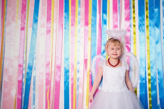 Portrait of beautiful princess girl in white dress with white nimbus and wings