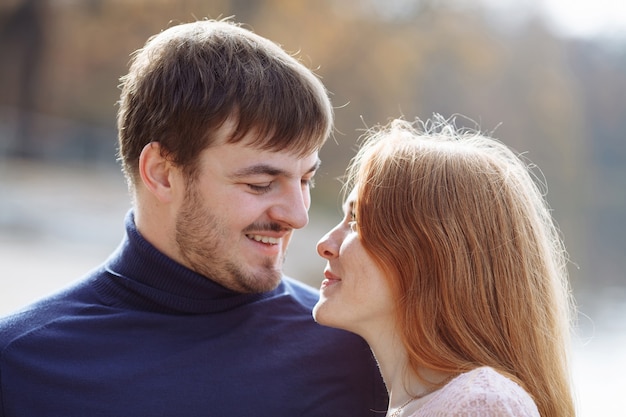 Portrait of a beautiful red-haired girl with her beloved husband with a beard