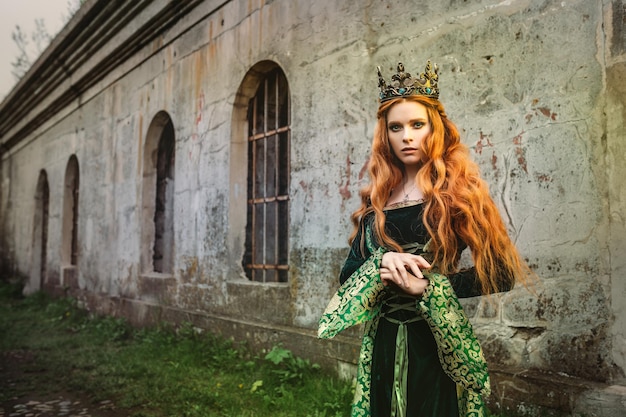Портрет красивой рыжеволосой женщины в зеленом средневековом платье