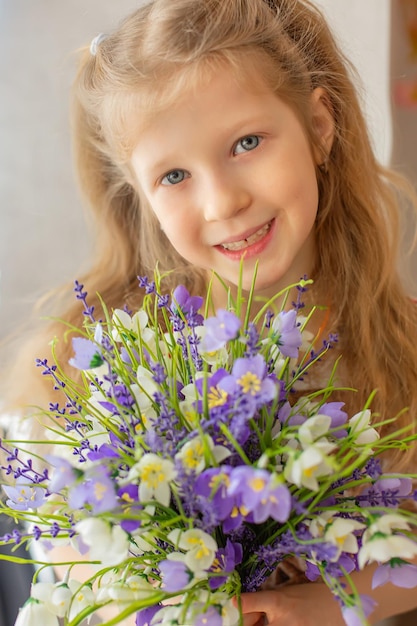 portrait of a beautiful redhaired girl with spring flowers in her hands